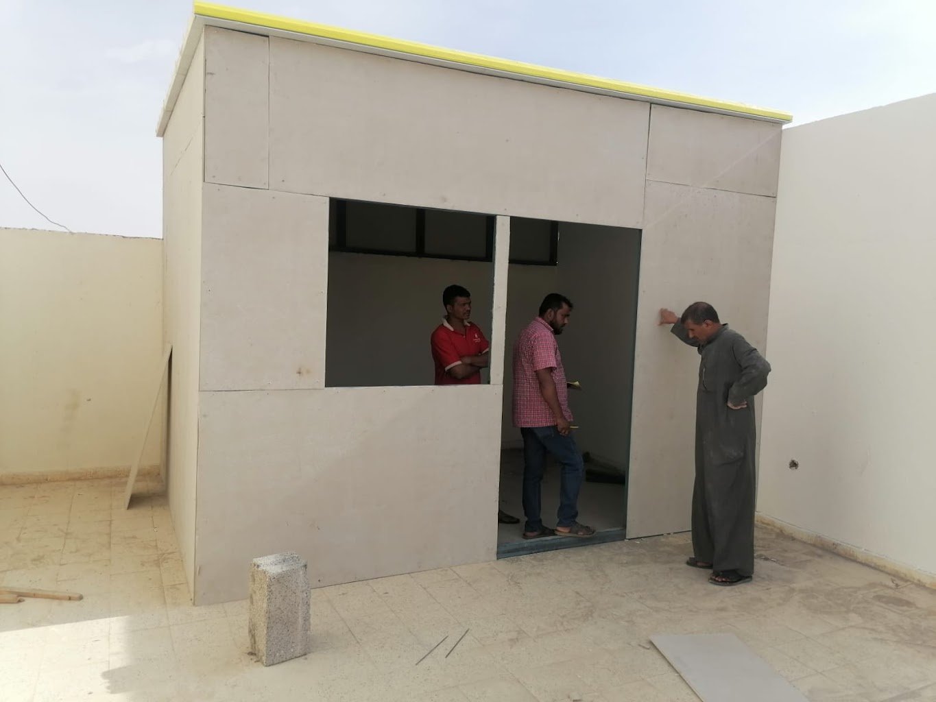 غرفة خارجية صغيرة بكسوة فاتحة أثناء التنفيذ